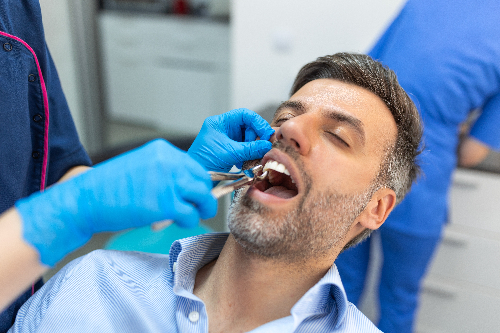 man having a tooth extracted in Bow, NH