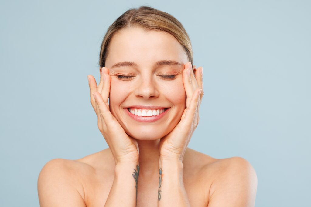 flawless smiling woman against a light blue background