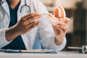 doctor holding up a denture model